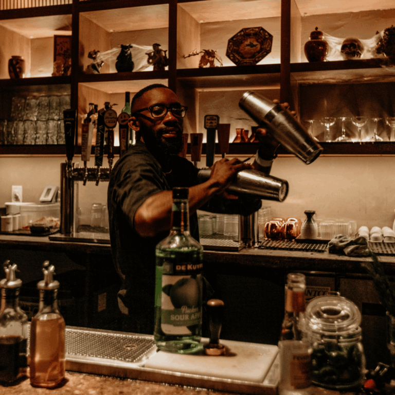 Bartender pouring from a bottle behind a bar
