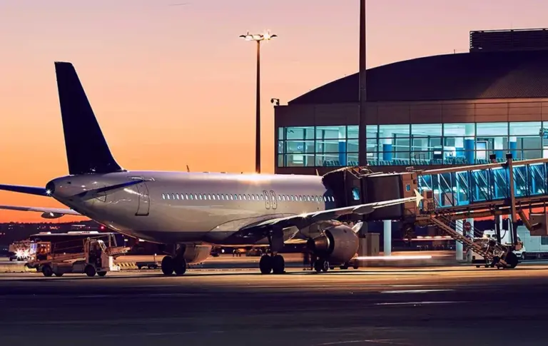 Airplane at an airport terminal gate at sunset