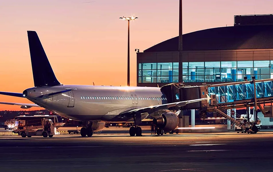 Airplane at an airport terminal gate at sunset